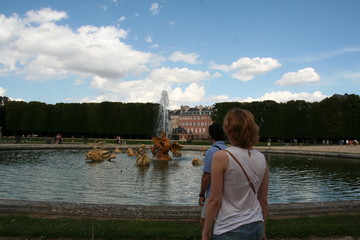 Tourists looking at the beautiful Versailles fountain in the summer cloudy sunny day