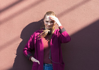 fashion girl posing near a lilac wall