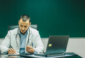 Doctor working on laptop in office