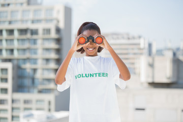 Smiling woman with volunteer tshirt using binoculars 