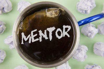 Text sign showing Mentor. Conceptual photo Person who gives advice or support to a younger less experienced written on Black Tea in Cup within Crumpled Paper Balls on plain Green background.