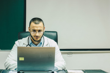 Doctor working on laptop in office