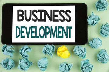 Conceptual hand writing showing Business Development. Business photo text Develop and Implement Organization Growth Opportunities written on Mobile Phone Screen on the plain background Paper Balls.