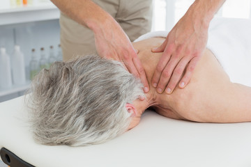 Physiotherapist massaging a senior womans back