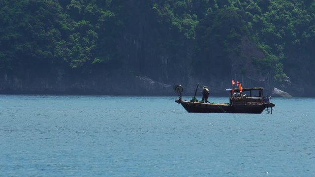 Fishermen pulling fishing nets In Cat Ba Harbor, Halong Bay, Vietnam