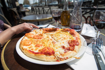 Greasy cheese pizza outside in a cafe patio