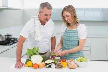 Happy couple preparing food together in kitchen