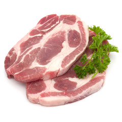 Raw pork neck chop meat with parsley herb leaves garnish isolated on white background cutout