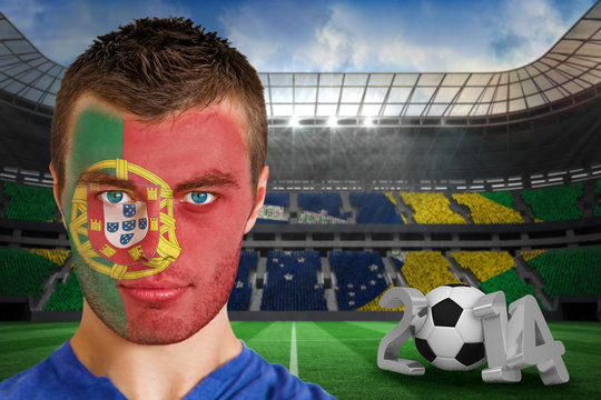 Composite image of serious young portuguese fan with face paint against large football stadium