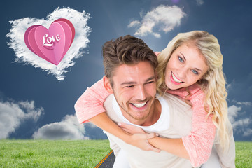 Handsome man giving piggy back to his girlfriend against cloud heart
