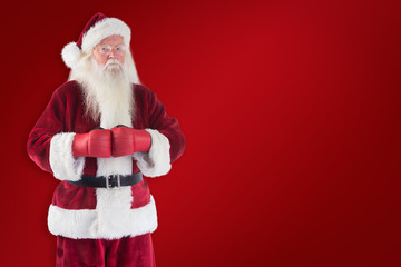 Santa Claus wears boxing gloves against red background