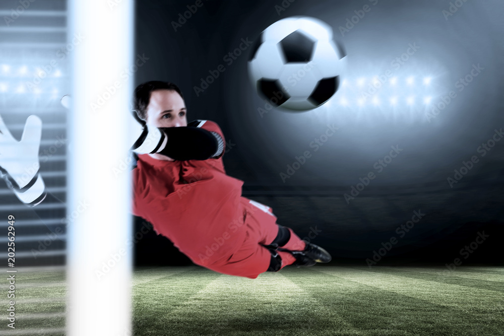 Canvas Prints fit goal keeper jumping up against football pitch under spotlights