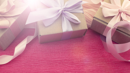 Banner Festive composition three Kraft boxes with gifts on bright pink background.