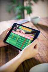 Woman using tablet pc  against gambling app screen