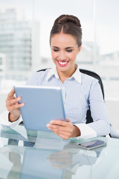 Happy brunette businesswoman using tablet
