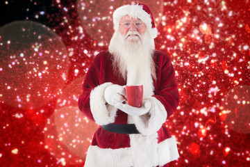 Santa holds a red cup against white snow and stars on red