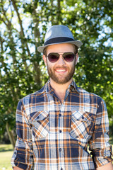 Handsome hipster smiling in the park