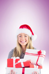 Festive blonde holding pile of gifts on vignette background