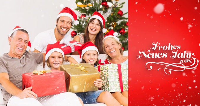 Happy family at christmas holding gifts against red vignette