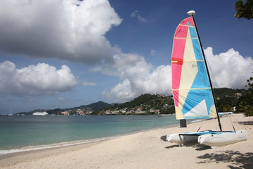 Beautiful Grand Anse beach with St Georges in the background & colorful boat in the foreground, Grenada, Caribbean.