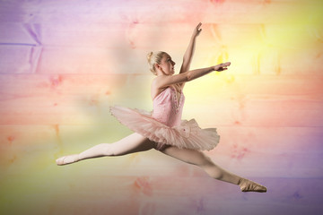 Pretty ballerina dancing against yellow and purple planks