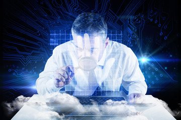 Mature businessman examining with magnifying glass against shiny blue hand print on circuit board