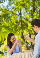 Fototapeta premium Couple toasting champagne flutes at an outdoor cafÃƒÂ©