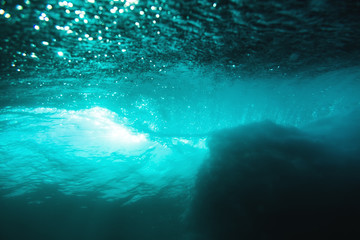 Fototapeta na wymiar Underwater barrel wave in ocean and sunshine. Water texture in ocean