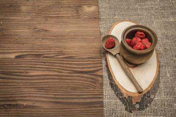 Herbal medicine concept. Dry strawberry in the jar on wooden brown table. Organic ingredients.