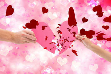 Obraz na płótnie Canvas Hands holding two halves of broken heart against digitally generated girly heart design