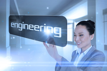 Fototapeta na wymiar Businesswoman pointing to word engineering against screen in room with sparks