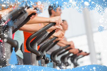 Fit people working out at spinning class against snow