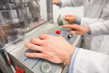 Obraz premium Pharmacist pressing button on machine