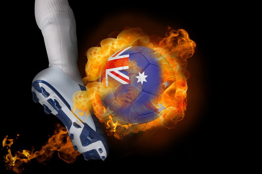Football player kicking flaming australia ball against black