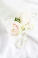 Fototapeta na wymiar Blur effect, soft focus flowers background with bouquet of pale pink ranunculus on white linen background .Beautiful Holiday background.copy space.