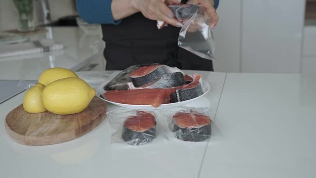 Female putting salmon steaks into vacuum bag