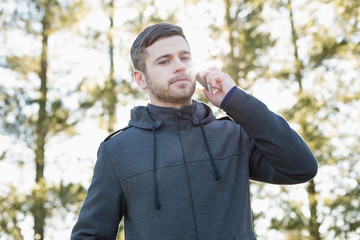 Serious man using mobile phone outdoors