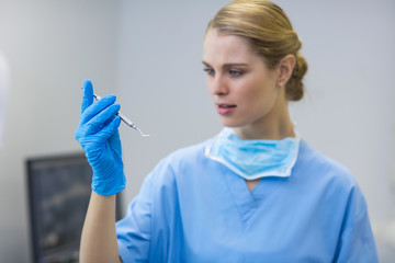 Female nurse holding dental tool