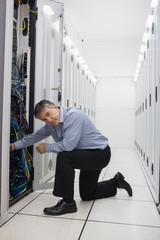 Technician kneeling and repairing a server