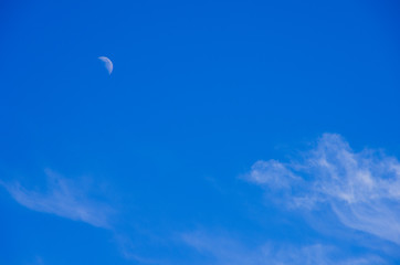 Crescent and clouds in the blue sky