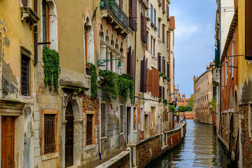 Fototapeta na wymiar Weathered building facade on a picturesque canal in Venice Italy