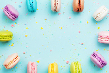 Colorful frame from cake macaron or macaroon on mint pastel background from above. French cookies...