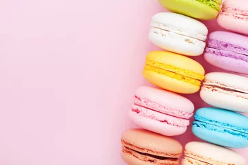 Poster French dessert macaron or macaroon on pink pastel background top view. Flat lay composition. © juliasudnitskaya