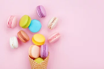 Vlies Fototapete Macarons Süßer Waffelkegel mit Makronen oder Makronen auf rosa Pastellhintergrund-Draufsicht. Flache Zusammensetzung.