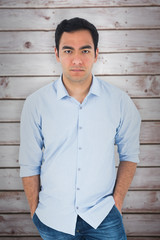 Obraz premium Unsmiling casual man standing against wooden planks