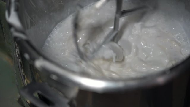 4K Slow Motion Movie of Flour, White Eggs and Water  in dough mixing machine, bakery ingredient mixed in the machine