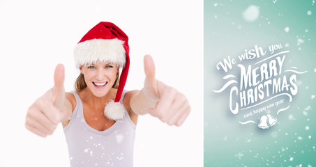 Woman with the thumbs up and a Christmas hat against green vignette
