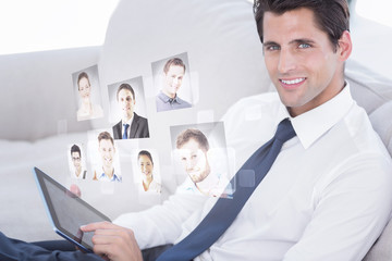 Smiling businessman using digital tablet against profile pictures