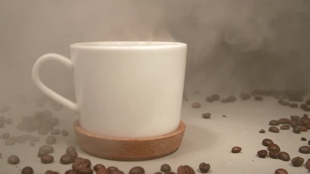 Smoke blows on a white cup with coffee,