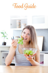 The word food guide against bright woman eating salad in the kitchen